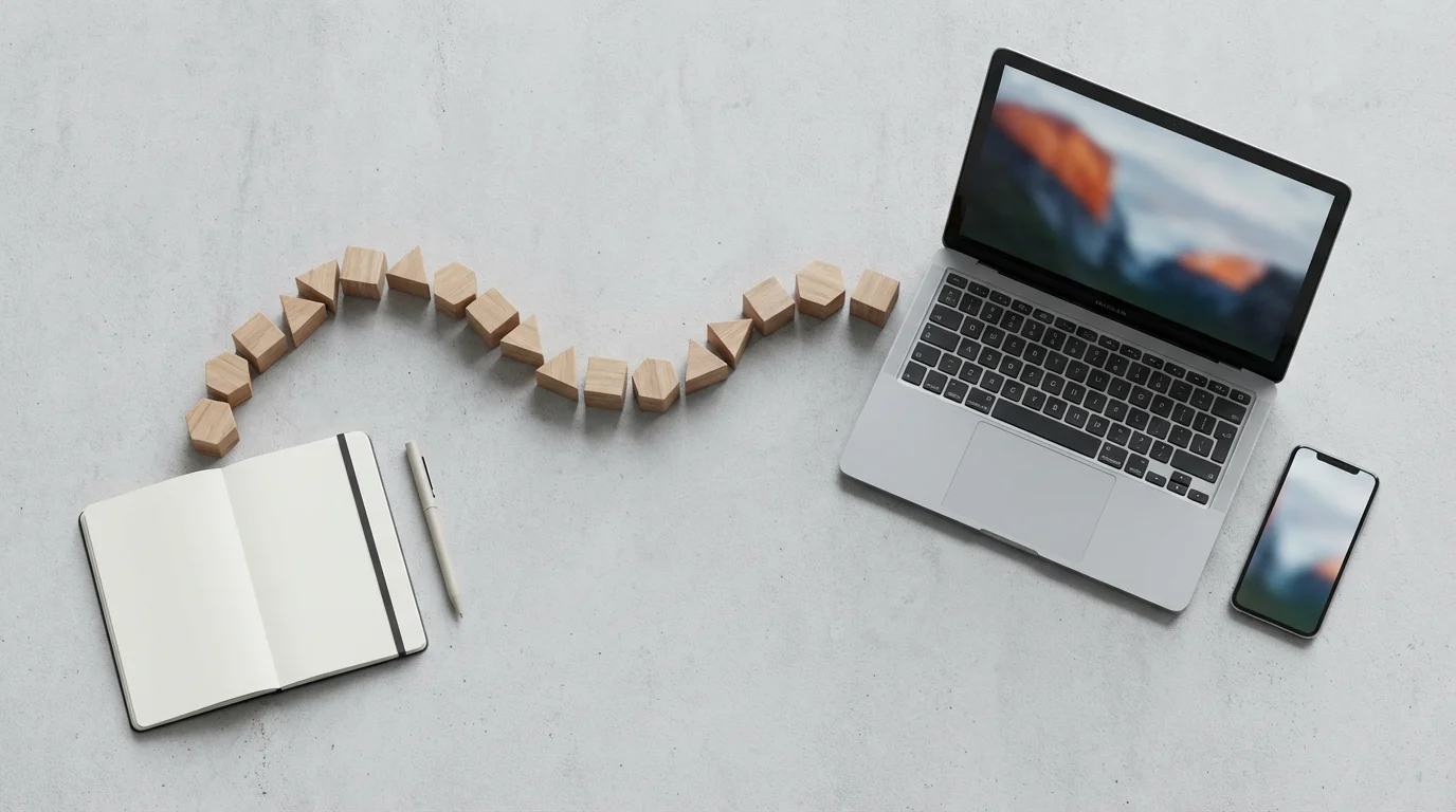 Flat lay of a laptop, notebook, and wooden blocks symbolizing an automated workflow.