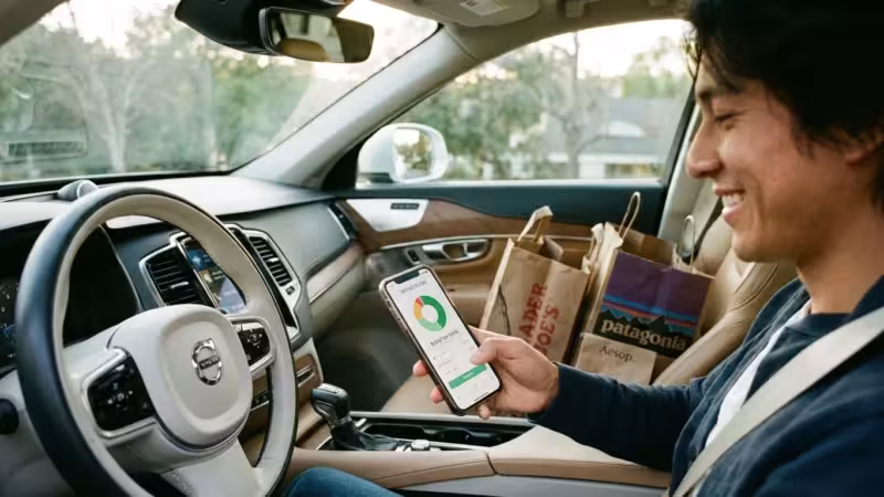A couple reviews their household budget on a tablet in a bright, modern kitchen.