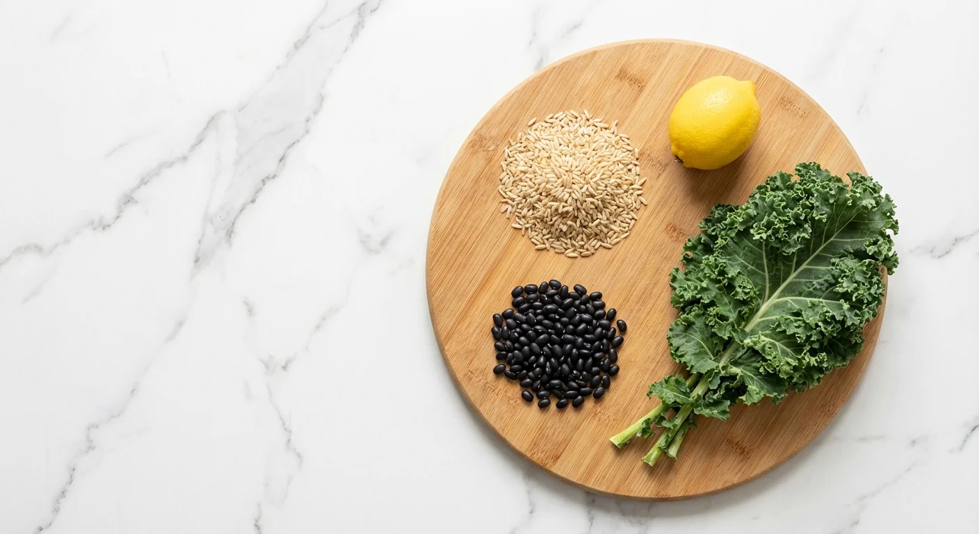 Flat lay of grocery staples like rice, beans, and kale on a marble counter.
