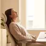 A professional person working calmly at a sunlit desk, representing financial clarity.